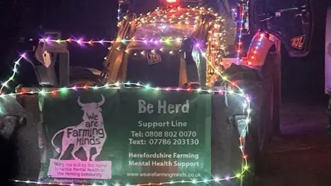 We are Farming Minds A tractor at last week's Herefordshire run has the green and white Be Herd sign used by We are Farming Minds, on its front. The charity offers a support line for farmers in need of support.