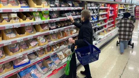 Getty Images Woman shops for groceries