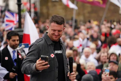 PA Media Tommy Robinson holding mic