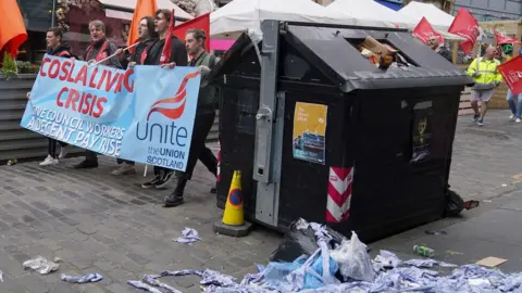 PA Media workers on strike in near to full bin in edinburgh