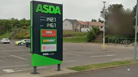 An ASDA petrol station sign in a carpark.