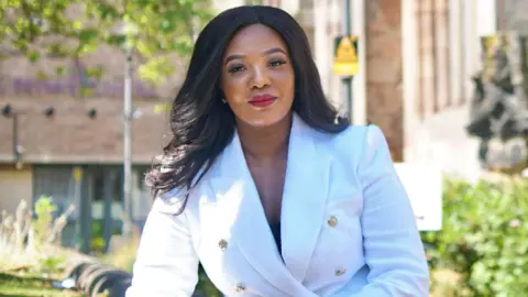 Derbyshire Police and Crime Commissioner Nicolle Ndiweni-Roberts. She has dark hair and is wearing a white suit jacket.
