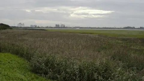 Tom Richardson / WikiCommons A shot, from a distance, of the former ICI works in Thorton-Cleveleys. It can be seen on the horizon over marsh land