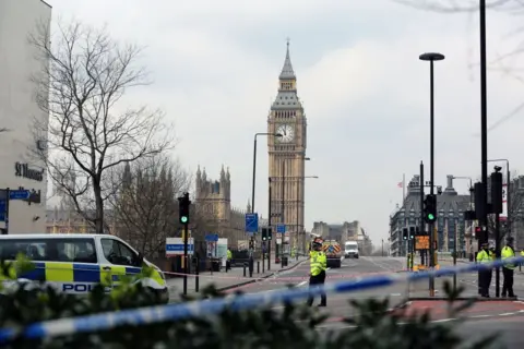 Anadolu Agency/Getty Images Police take security measures at Westminster Bridge after a car ran over people on the bridge during a terror attack. Police tape covers the entrance to the bridge and police vans and officers are seen in the vicinity.