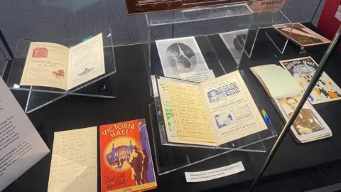 Historical programmes in a museum display cabinet