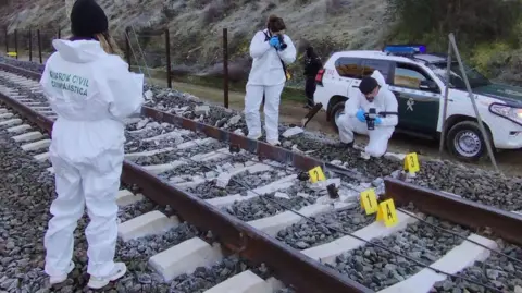 EPA Spanish Civil Guard shows officers gathering evidence at the site of a train crash in Spain.