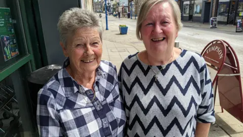 Pat Firth and Mary Kiernan smile for the camera on Rothwell's main street