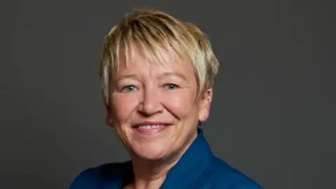 UK Parliament A headshot of Rachel Taylor MP. She has short blonde hair and is smiling towards the camera over her left shoulder. 