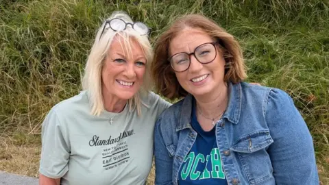 Sally Gower (left) and Hayley Spence (right). Sally is wearing a green shirt and has long blonde hair. Hayley is wearing a denim jacket and blue top. She is also wearing glasses and has brunette hair.
