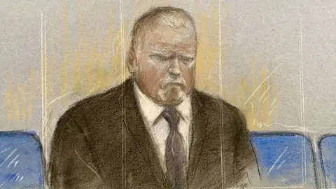 Courtroom sketch showing Robert Bush seated alone behind a glass front shown as vertical sketch marks in beige and white. He is wearing a dark suit, white shirt and dark tie. The illustration is rendered in pastel and pencil tones, with blue courtroom seats visible on either side of the figure. He is positioned centrally against a pale grey background.