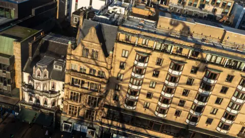 Shadow of a big wheel on a tenement building
