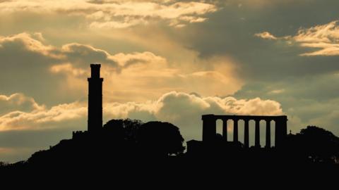 Calton Hill in silhouette against a sunset