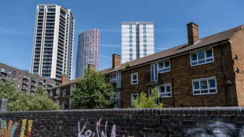 Low rise flats in the foreground and  three new tower blocks in the background in Stratford, Newham.