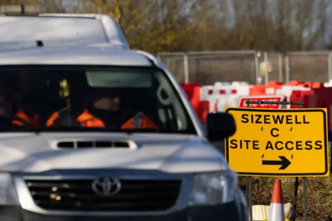 A white van passes the sign to the Sizewell C site