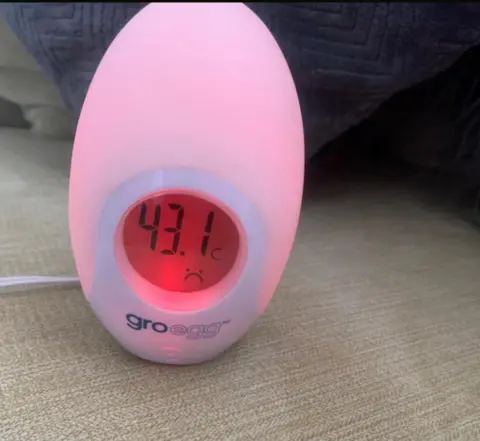 A pink temperature gauge measuring 43 degrees in a house