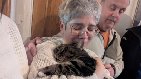 RSPCA A woman looking emotional cuddling a cat 