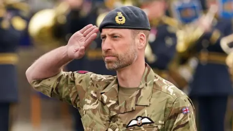 Reuters Prince William, performing a salute. He is wearing a RAF military pattern camouflage uniform.
