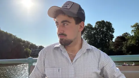 Hussein Hussein is in a cap looking to the side 