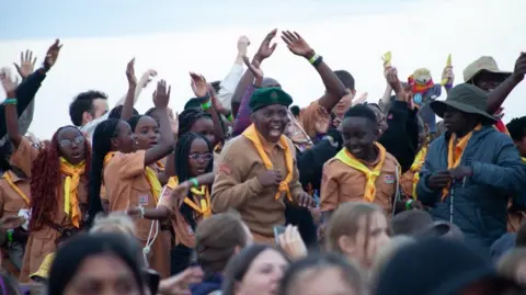 Guides and scouts from Kenya dancing and smiling at a jamboree