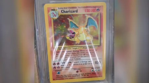 Sussex Police A close up of a Charizard Pokemon card showing a big image of a golden dragon breathing fire