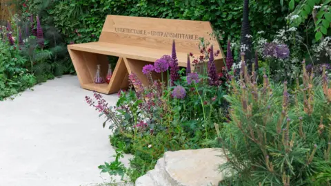 RHS/Neil Hepworth A bench sits in the garden with the words 'Undetectable = Untransmittable' written on it as a sign of