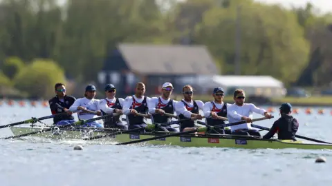 Getty Images A team of eight rowers plus a coxswain on a long, green rowing boat.