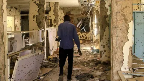 AFP via Getty Images A destroyed hospital in Khartoum in 2023 that is riddled with bullet holes.
