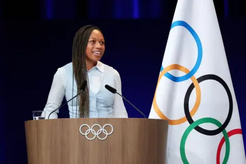 Getty Images Allyson Felix speaks at an Olympic podium after being elected to the International Olympic Committee Athletes' Commission