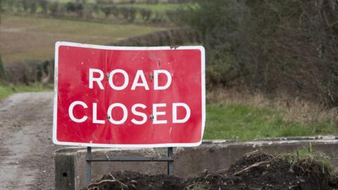 View of Red 'Road closed' sign on closed rural road
