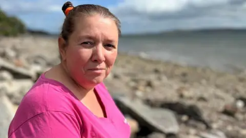 Michelle McClymont at a beach and sea in the background