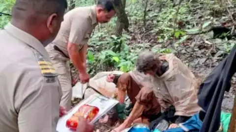 BBC Lalita Kayi is assisted by police officers in the forests of Maharashtra state. 