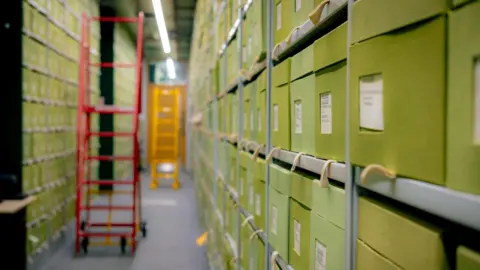 Sebastian Kettley/RBG Kew/PA Wire A room filled with shelves and labelled storage boxes. A red ladder and a yellow ladder are out of focus in the background.