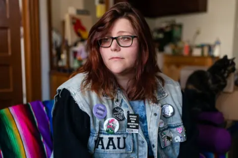 Lauren Handy, pictured in 2022 wearing glasses and a sleeveless denim jacket covered in anti-abortion campaign badges