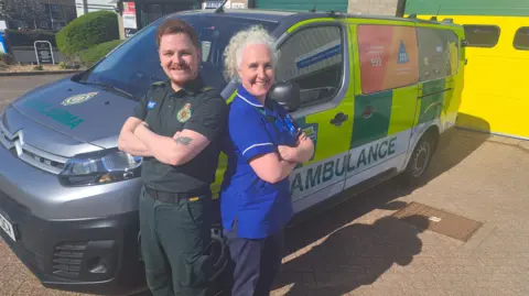 SCAS An ambulance paramedic and NHS staff member standing beside a SCAS ambulance
