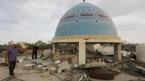 Getty Images Palestinians inspect the rubble of a mosque, which was damaged in Israeli attack in Deir al-Balah, Gaza on 6 October, 2024