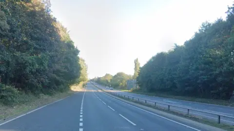 A general view of the eastbound A14 carriageway close to Bury St Edmunds. The road is lined with trees and is relatively empty of traffic.