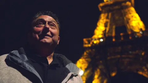 Madoc Roberts Steven di depan Menara Eiffel di malam hari