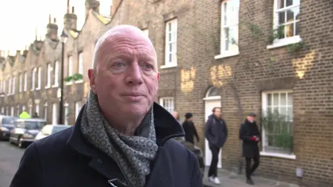 Matt Wrack from the Fire Brigades Union - a man wearing a black trench coat and patterned scarf