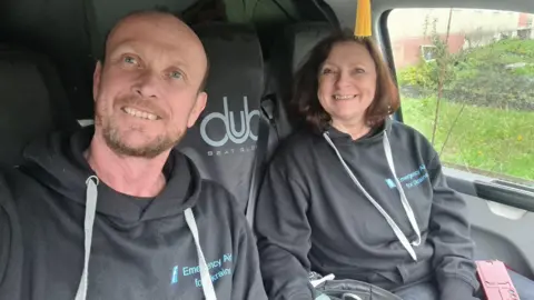 Brian and Helen Hammond sat in a van