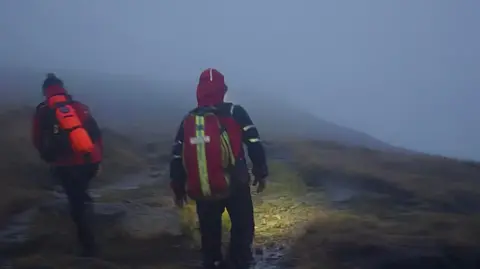 Two volunteers on a hill in the dark