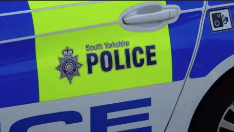An image of the rear of a police marked car with the South Yorkshire Police logo in blue on a luminous yellow background