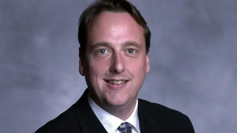 Wiltshire Council The leader of the Liberal Democrats at Wiltshire Council, Ian Thorn, poses for a picture in black suit, white shirt while wearing a colourful tie