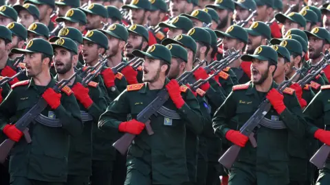 A picture of soldiers in a dark green uniform and red gloves. 