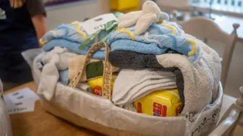 GMCA A baby bundle with a toy white rabbit and nappies in a basket