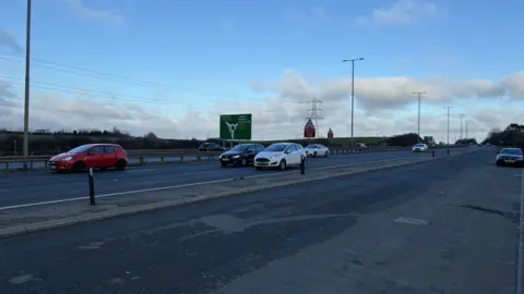 A130 in Essex - a large S road with cars moving along and a large road sign indicating directions to Southend and Benfleet