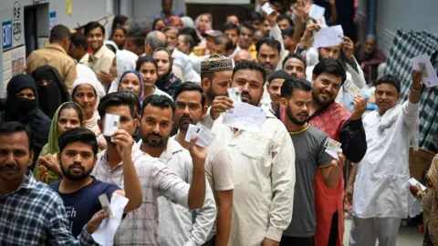 Getty Images NEW DELHI, INDIA - MAY 25: Voters are seen standing in line to cast their votes during the sixth phase of Loksabha Elections at a polling station in Rajiv Nagar on May 25, 2024 in New Delhi, India.  Voting for the sixth phase of the general election has concluded in 58 constituencies across six states and two Union territories, including all seven seats in Delhi.  According to the Election Commission's Voter Turnout App, voter turnout across six states and two Union Territories in Phase 6 polling was recorded at approximately 58.84 per cent.  (Photo by Sanchit Khanna/Hindustan Times via Getty Images)