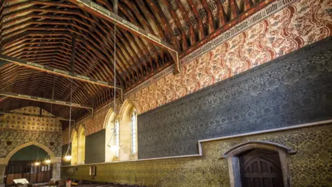 Adrian Powter The interior of All Saints' Church in Cambridge. Every part of the interior is decorated in colourful medieval gothic-style patterns, including the wooden roof. 