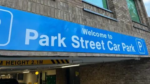 A blue sign on a car park entrance which says, Welcome to Park Street Car Park