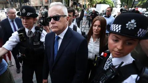 EPA Huw Edwards is seen alongside police officers
