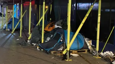 BBC Tents underneath scaffolding outside a Liverpool city centre building at night